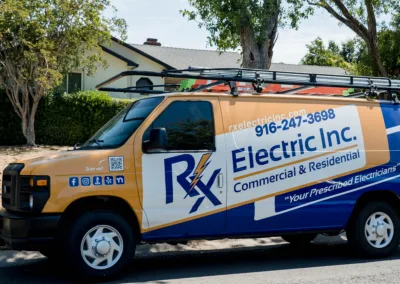 A commercial van from rx electric inc. parked by the roadside, advertising electrical services for commercial and residential clients.