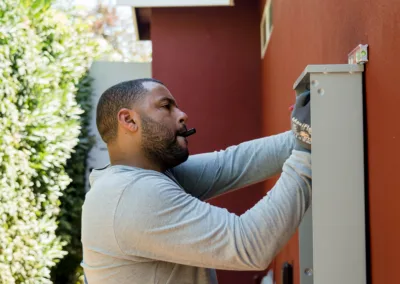 Man inspecting or working on an outdoor electrical panel.