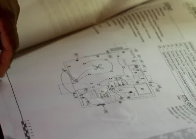 Person reviewing architectural blueprints with visible sketches and annotations.