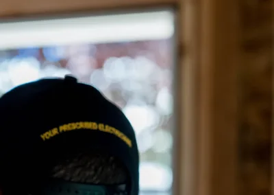 A person wearing a baseball cap seen from behind, looking outward from a dimly lit interior space.