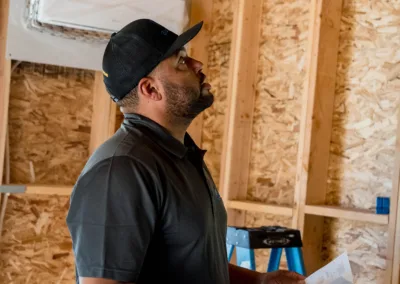 Man inspecting construction site with plans in hand.