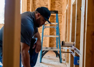 Construction worker reviewing plans inside a building under construction.