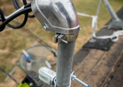 Satellite dish installation with a close-up of the lnb arm and coaxial cables on a residential rooftop.