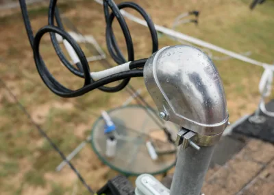 A home-built antenna mounted on a metal pole with a suburban backyard in the background.