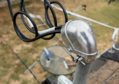 A home rooftop antenna with a triple loop design under an overcast sky.