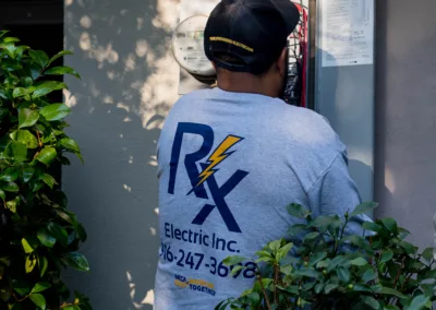 An electrician from r.k. electric inc. working on an outdoor electrical panel.