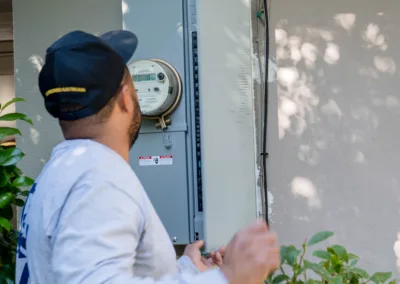 A technician inspecting an outdoor electrical panel.