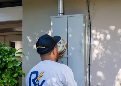 An electrician inspecting an outdoor electrical panel.