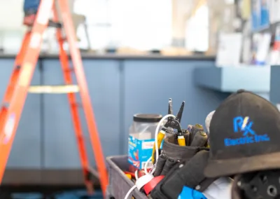 Two workers installing equipment with focus on the toolbox in the foreground.