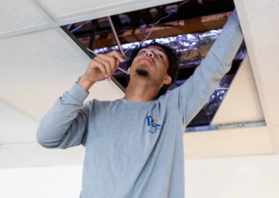 A man installing or repairing a ceiling tile.