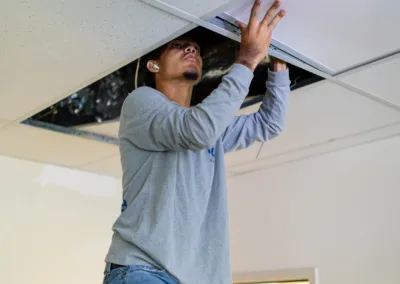 Man installing a ceiling tile.