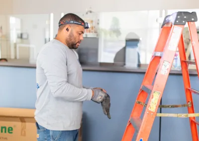 Man preparing to use a ladder for maintenance work indoors.